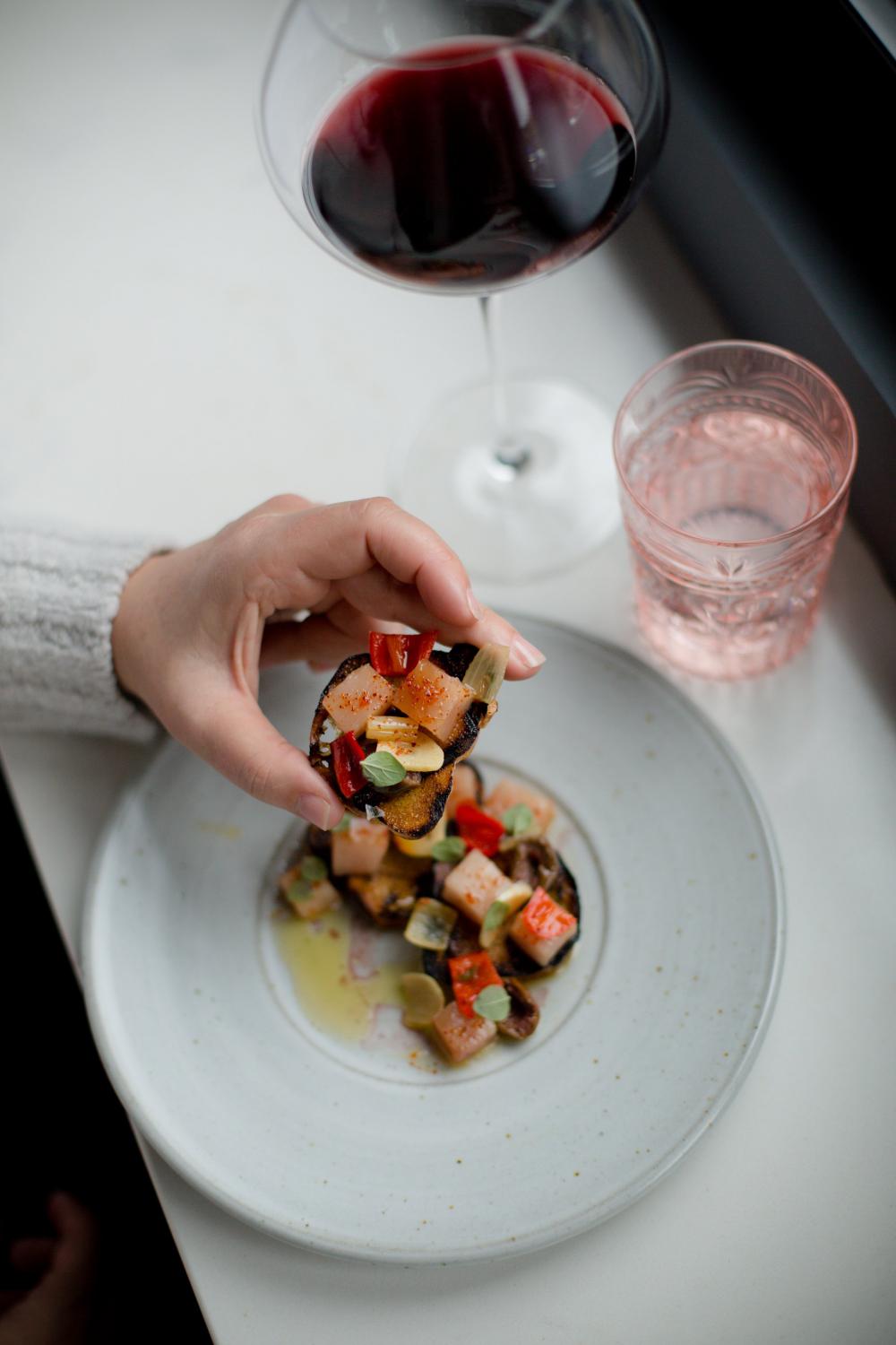 Hand Holds A Crostini Appetizer Photo Hand Holds A Crostini Appetizer Photo