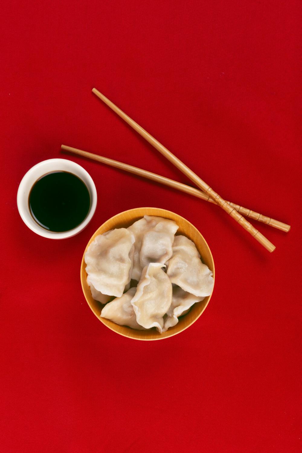 Dumplings Chopsticks And Sauce On A Red Cloth Viewed From Above Photo Dumplings Chopsticks And Sauce On A Red Cloth Viewed From Above Photo