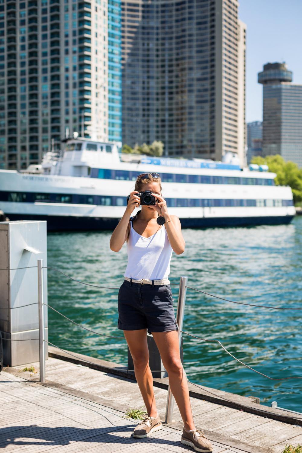 Person Stands By Waterfront And Holds Camera Up To Take A Picture Photo Person Stands By Waterfront And Holds Camera Up To Take A Picture Photo