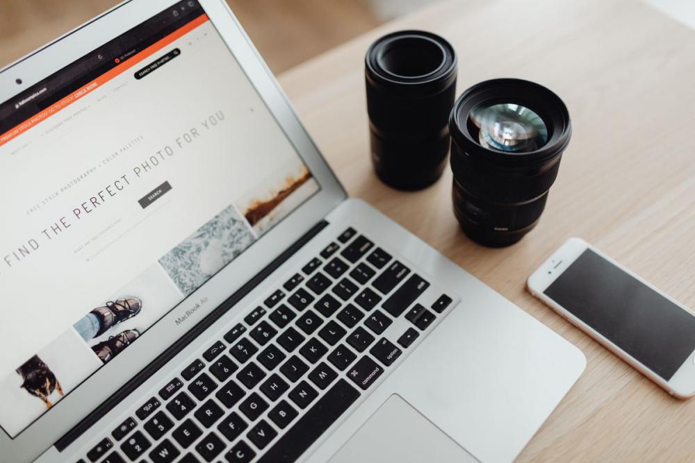 Laptop, phone mi photo lenses on desk Laptop, phone mi photo lenses on desk