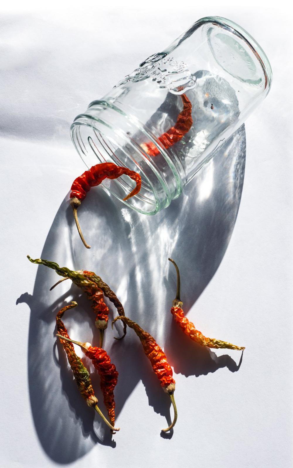 A Glass Jar With Red Chili Peppers Falling Out Of It Photo A Glass Jar With Red Chili Peppers Falling Out Of It Photo
