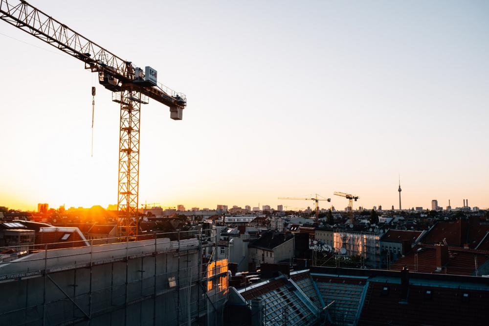 The Sunsets Over A City Rooftops And Tall Cranes Photo The Sunsets Over A City Rooftops And Tall Cranes Photo