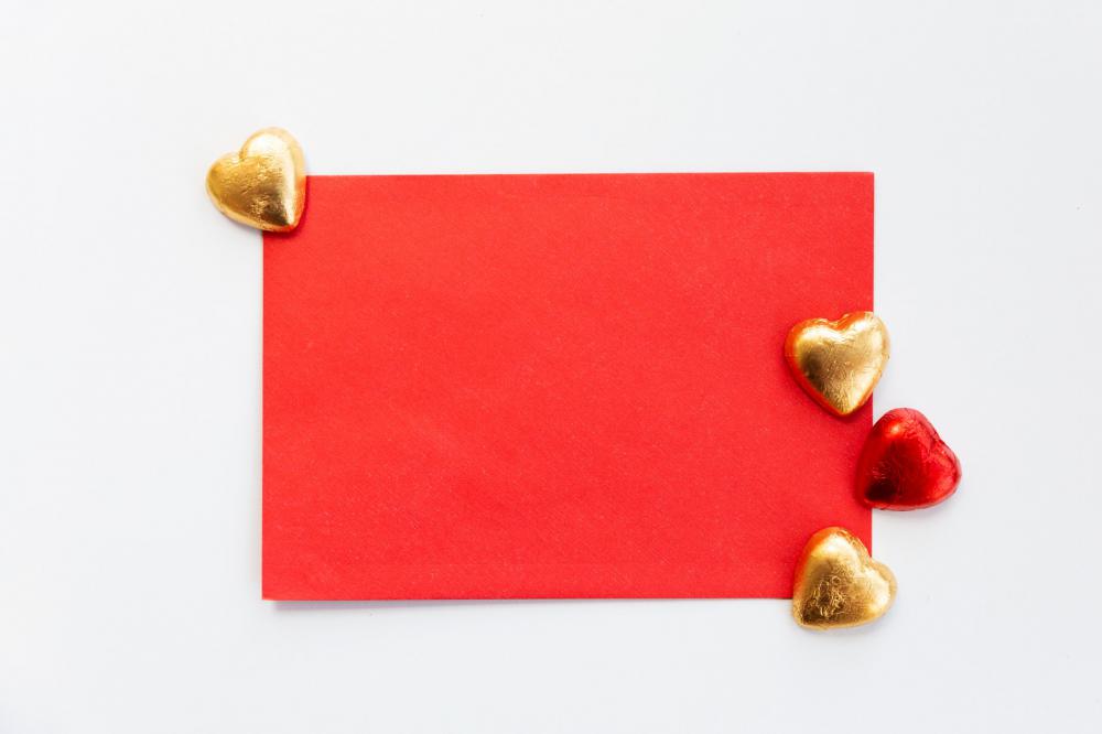 Flatlay Of A Red Envelope With Gold And Red Chocolates Photo Flatlay Of A Red Envelope With Gold And Red Chocolates Photo