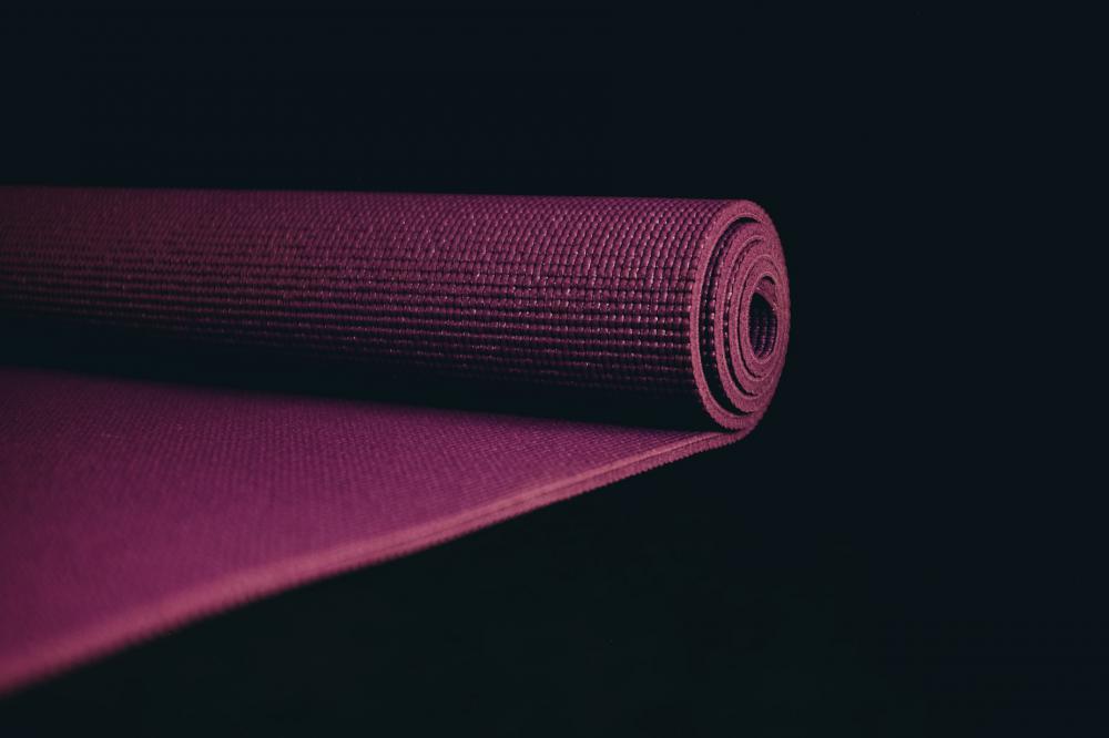Purple Yoga Mat Partially Rolled Up On Black Photo Purple Yoga Mat Partially Rolled Up On Black Photo