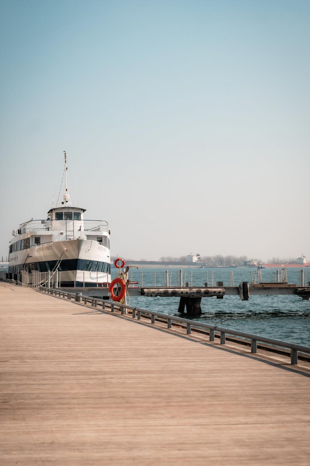 Large White Boat Docked By A Wooden Boardwalk Photo Large White Boat Docked By A Wooden Boardwalk Photo