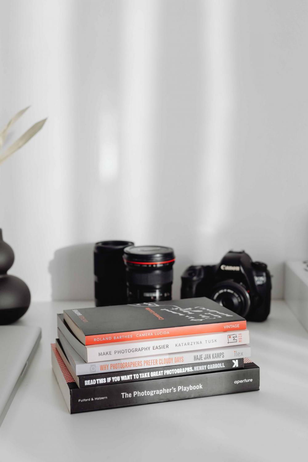 Photographer's desk - books, DSLR camera and lenses Photographer's desk - books, DSLR camera and lenses