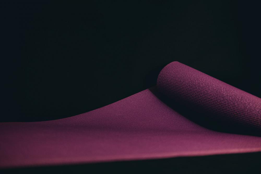 Purple Yoga Mat Unrolled On A Black Floor Photo Purple Yoga Mat Unrolled On A Black Floor Photo
