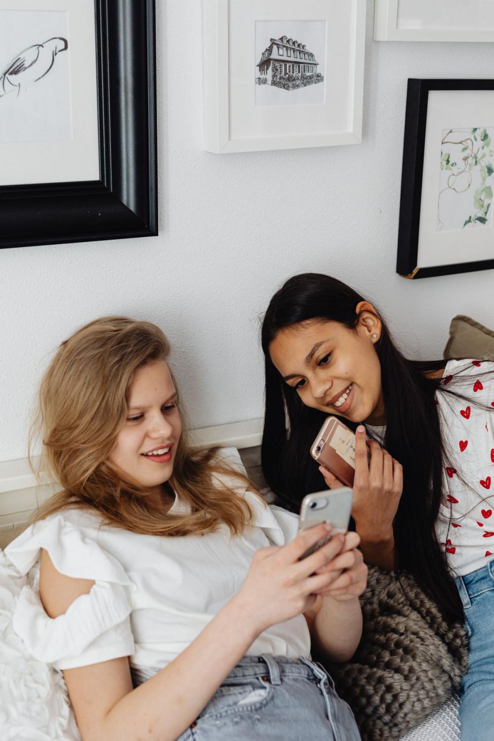 Teens sit together on the couch and use phones Teens sit together on the couch and use phones