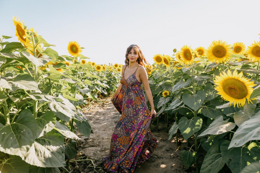Woman In A Floral Dress Stands In A Sunflower Field Photo Woman In A Floral Dress Stands In A Sunflower Field Photo
