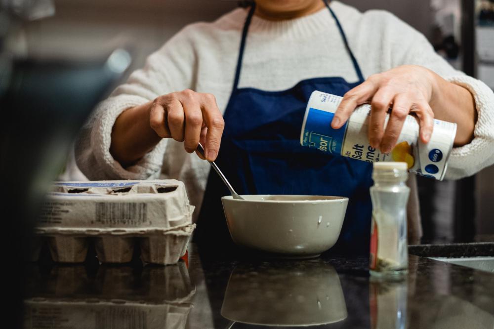 Person Stirs A Bowl And Holds Salt To Pour Photo Person Stirs A Bowl And Holds Salt To Pour Photo