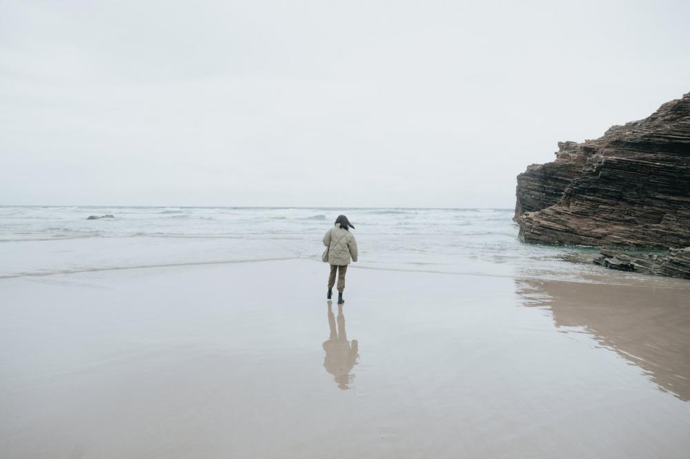 Person In A Warm Jacket Looks Out To The Ocean Photo Person In A Warm Jacket Looks Out To The Ocean Photo