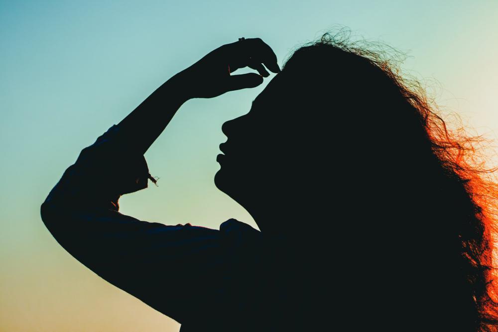 Silhouetted Person Running Hand Through Their Hair Photo Silhouetted Person Running Hand Through Their Hair Photo