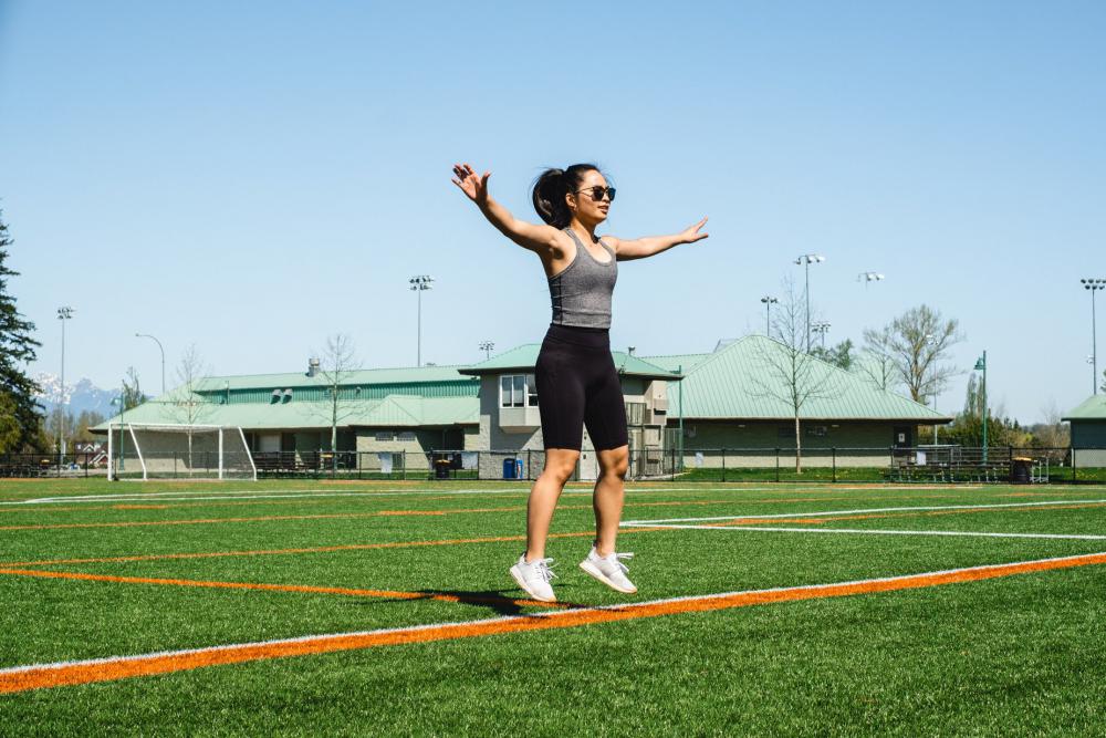 Woman Mid Jumping Jack Floats Above Green Grass Photo Woman Mid Jumping Jack Floats Above Green Grass Photo