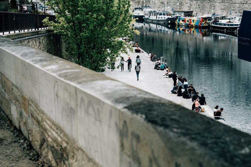 Canal With People Sitting And Boats Lining The Side Photo Canal With People Sitting And Boats Lining The Side Photo