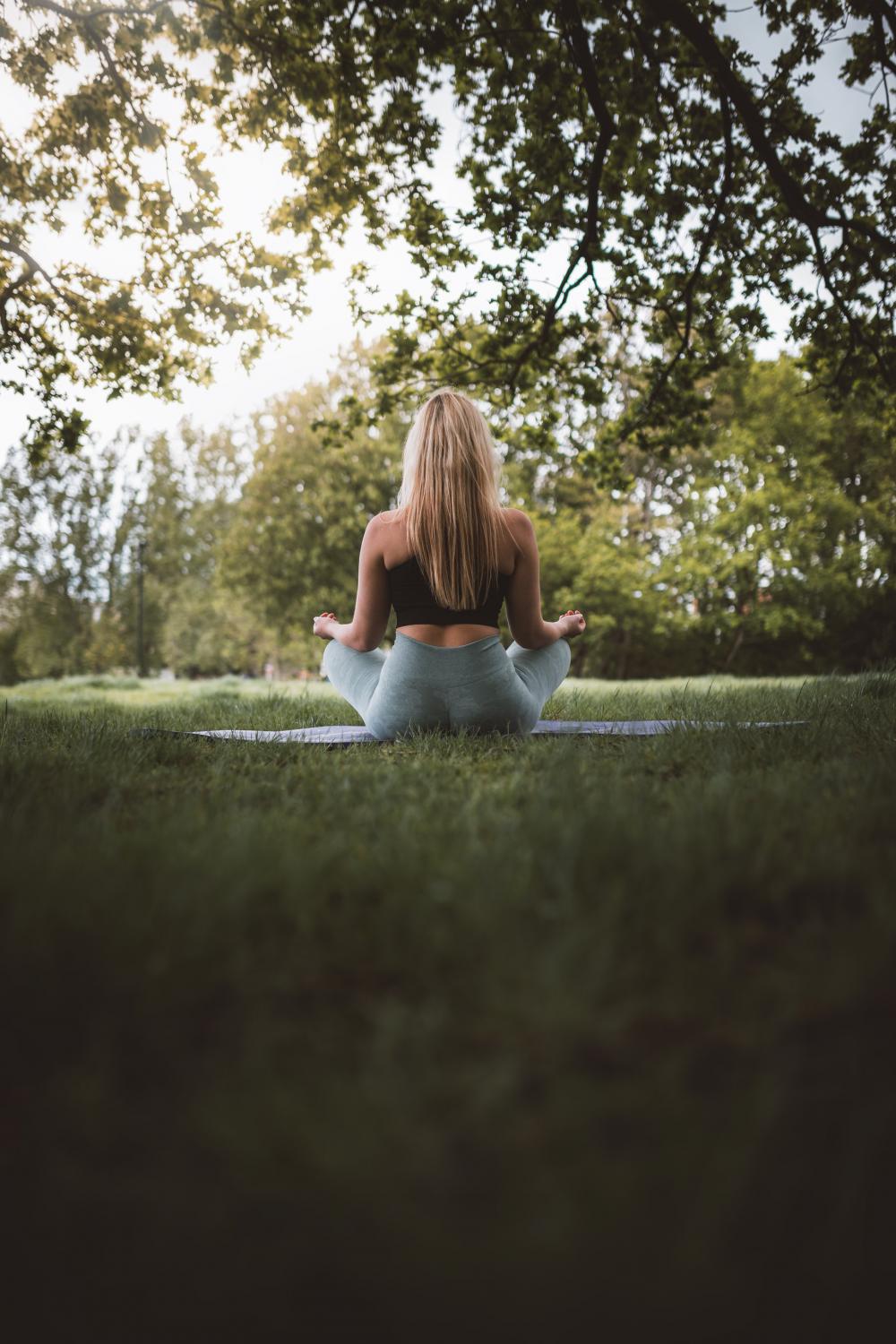 Back Of A Woman Sitting Outdoors On A Mat Photo Back Of A Woman Sitting Outdoors On A Mat Photo
