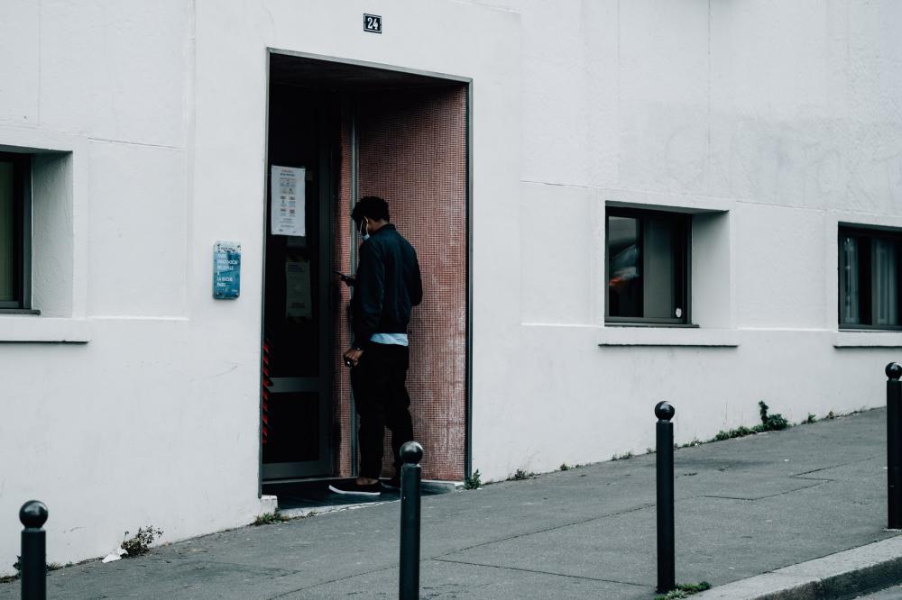 Person Waiting To Enter At A Building Entrance Photo Person Waiting To Enter At A Building Entrance Photo