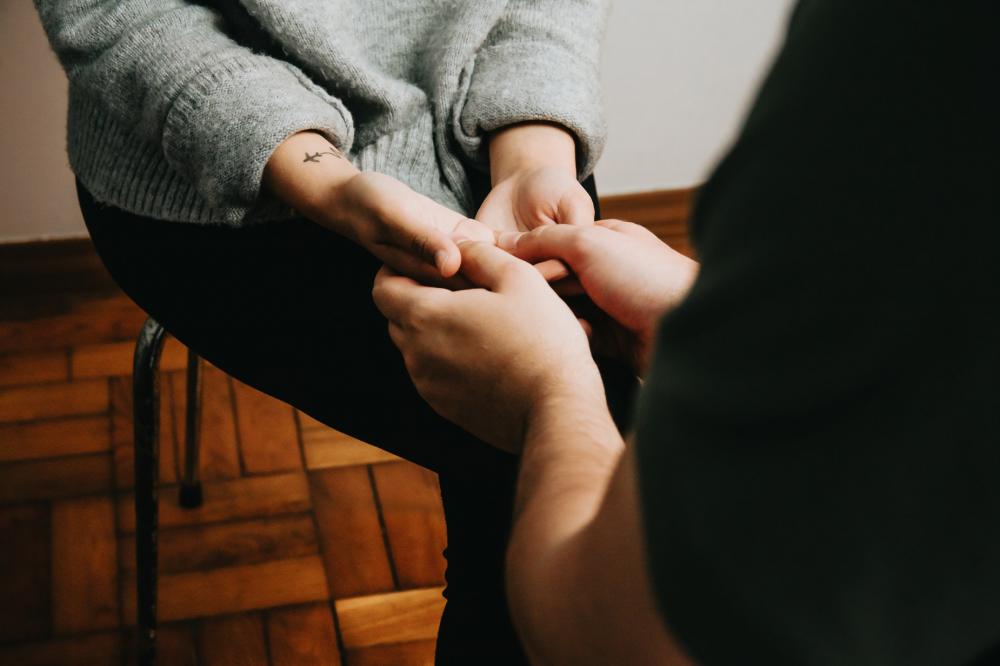 Two People Sitting Across From Each Other And Holding Hands Photo Two People Sitting Across From Each Other And Holding Hands Photo