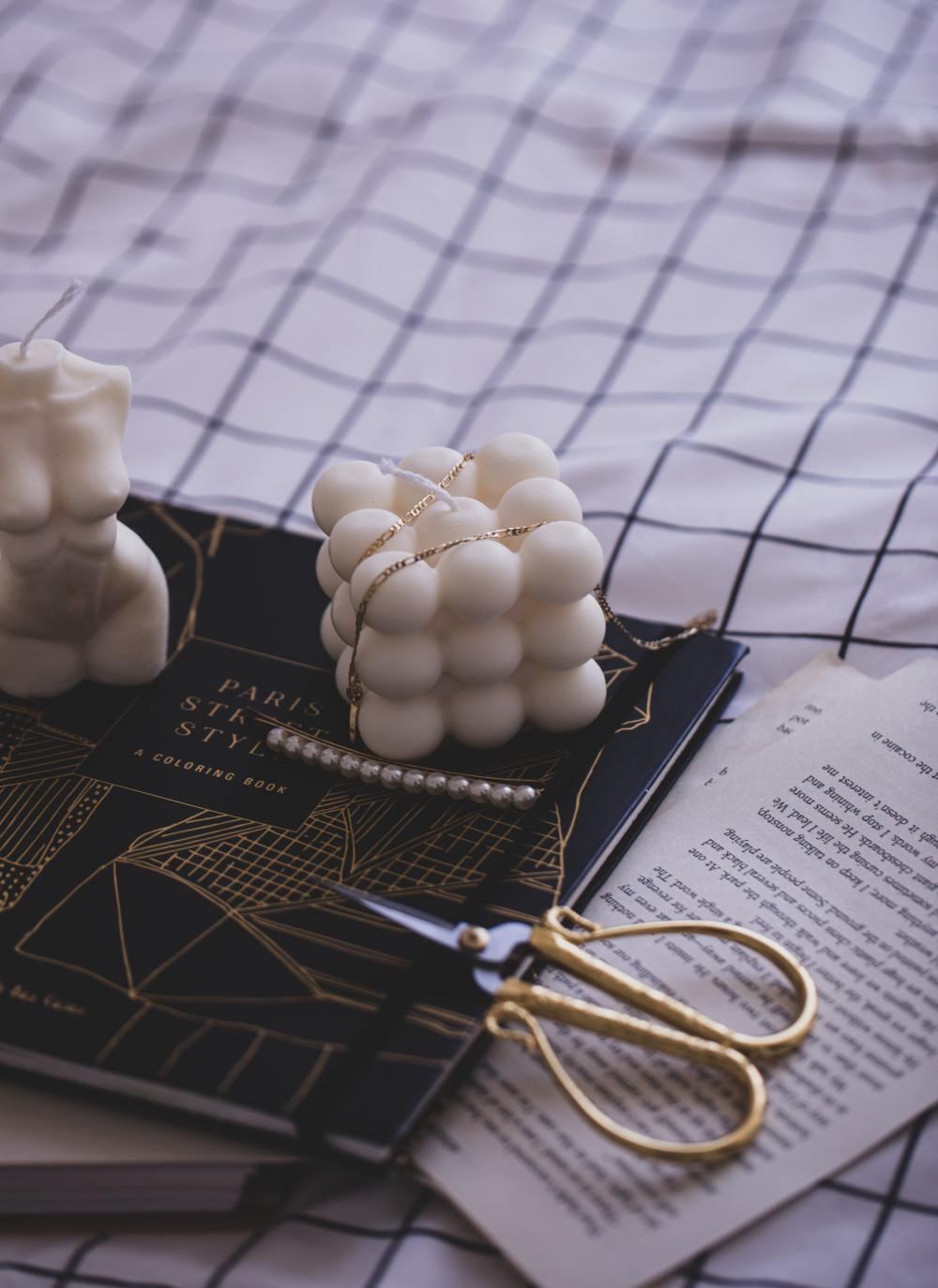 Unlit Candle On Book With A Draped Gold Necklace Photo Unlit Candle On Book With A Draped Gold Necklace Photo