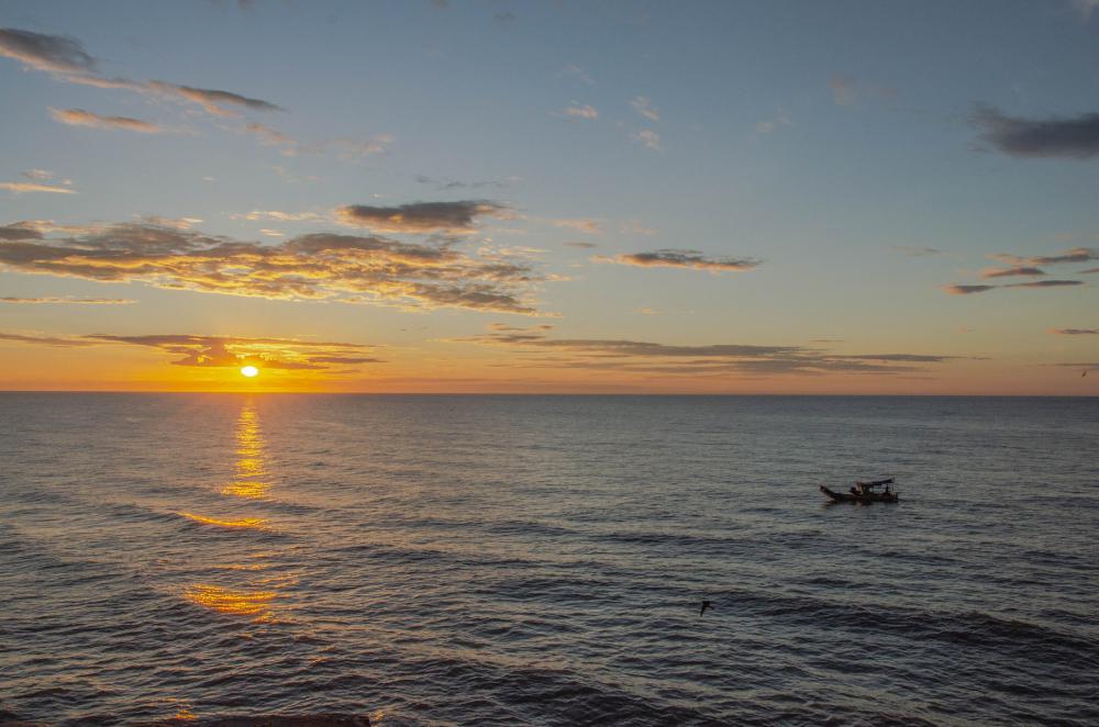 Sunset Silhouettes A Boat Riding On Wavy Water Photo Sunset Silhouettes A Boat Riding On Wavy Water Photo