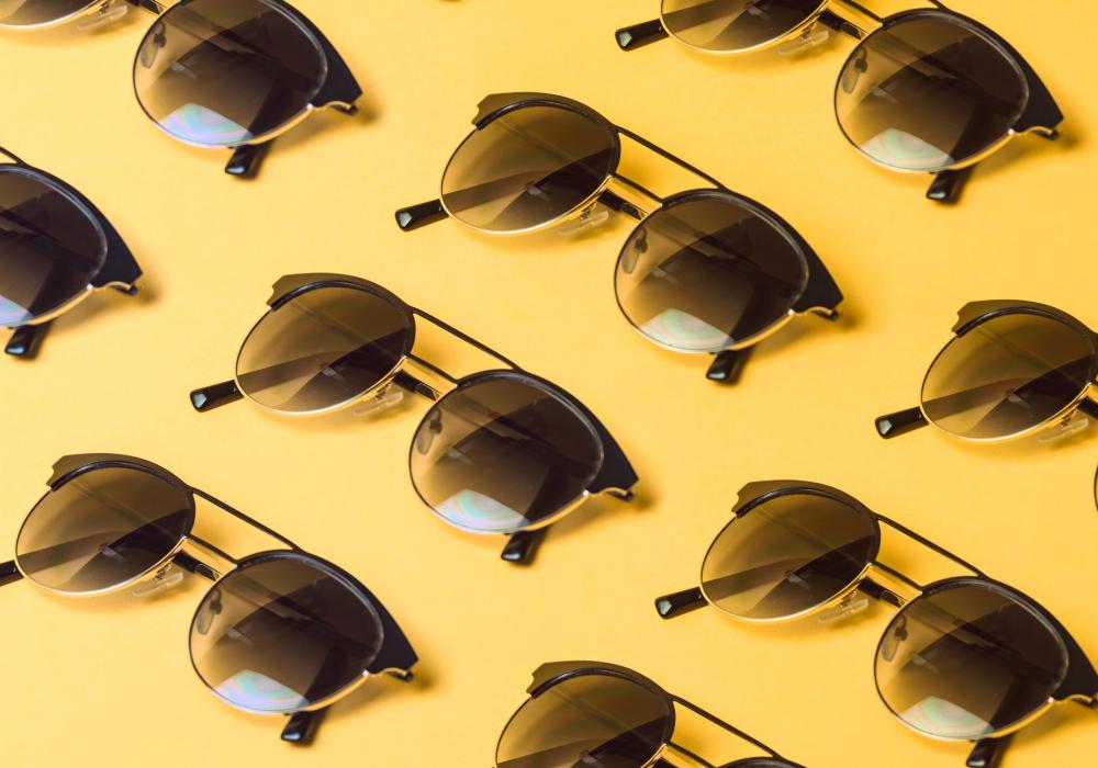 Round Black Sunglasses Repeated On Yellow Background Photo Round Black Sunglasses Repeated On Yellow Background Photo