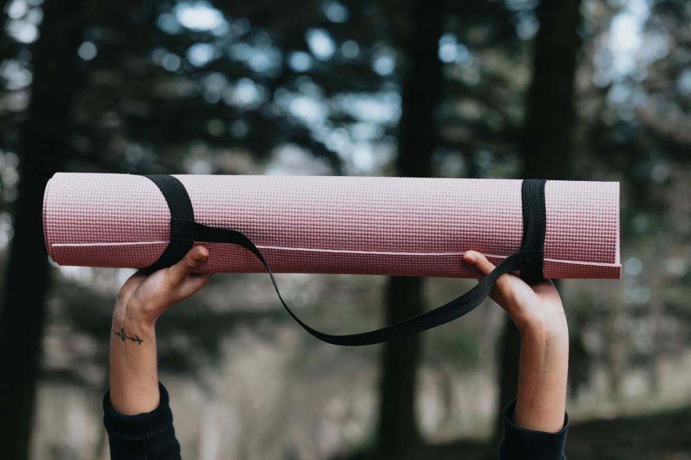 Hands Hold Up A Pink Yoga Mat Outdoors Photo Hands Hold Up A Pink Yoga Mat Outdoors Photo