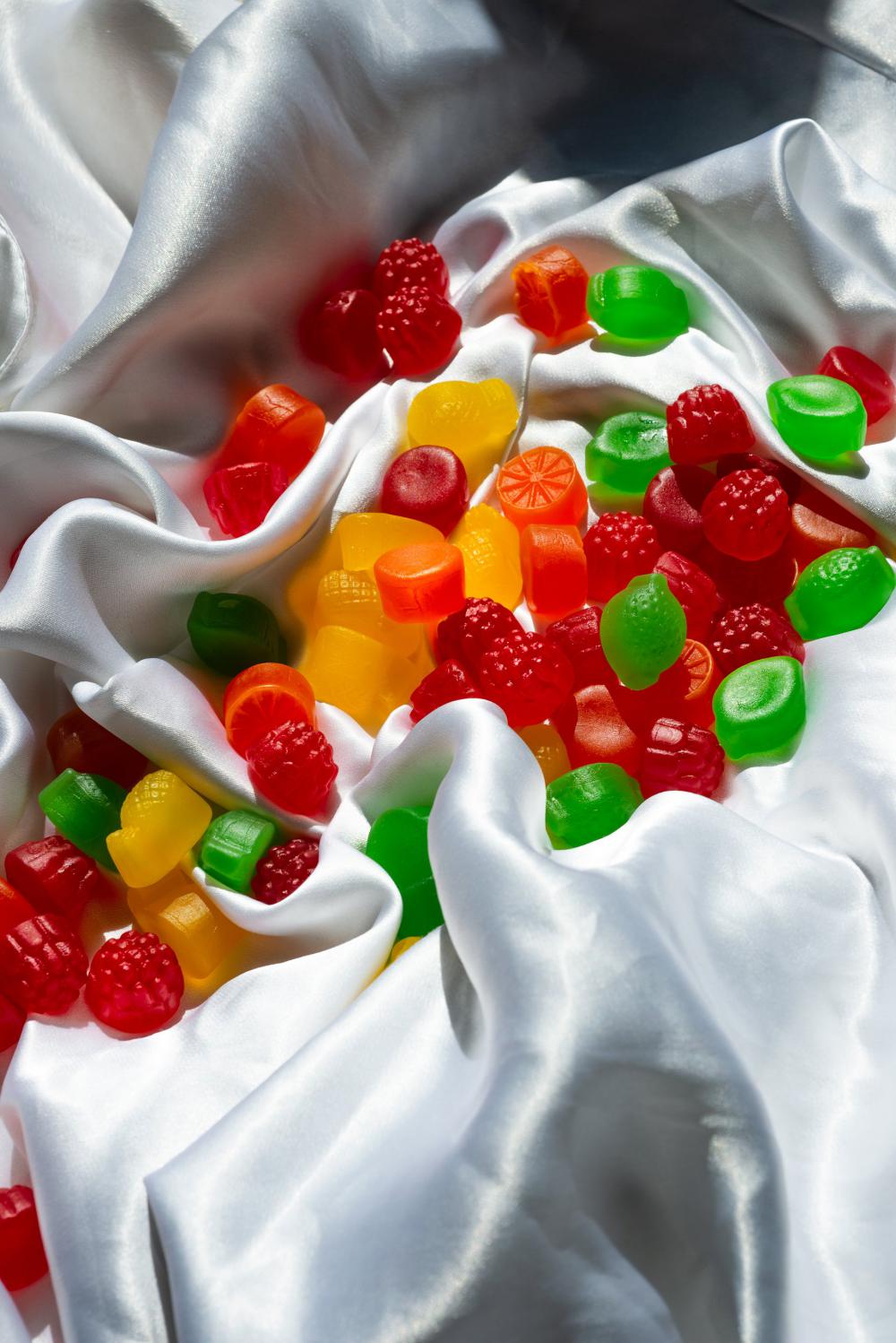 Colorful Jube Jubes Scattered On A White Silk Sheet Photo Colorful Jube Jubes Scattered On A White Silk Sheet Photo