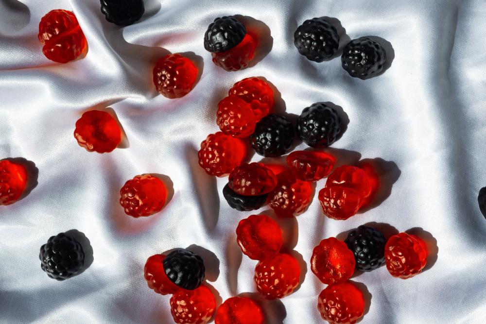 Red And Blue Gummies Lay On A White Silk Fabric Photo Red And Blue Gummies Lay On A White Silk Fabric Photo