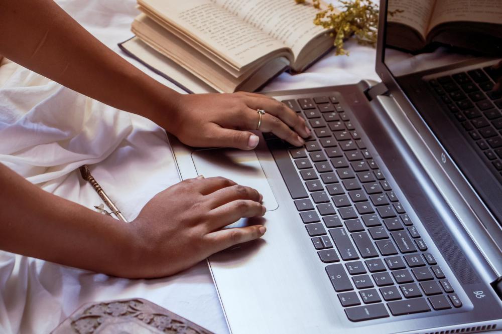 Hands Type On A Laptop That Is Resting On A White Cloth Photo Hands Type On A Laptop That Is Resting On A White Cloth Photo