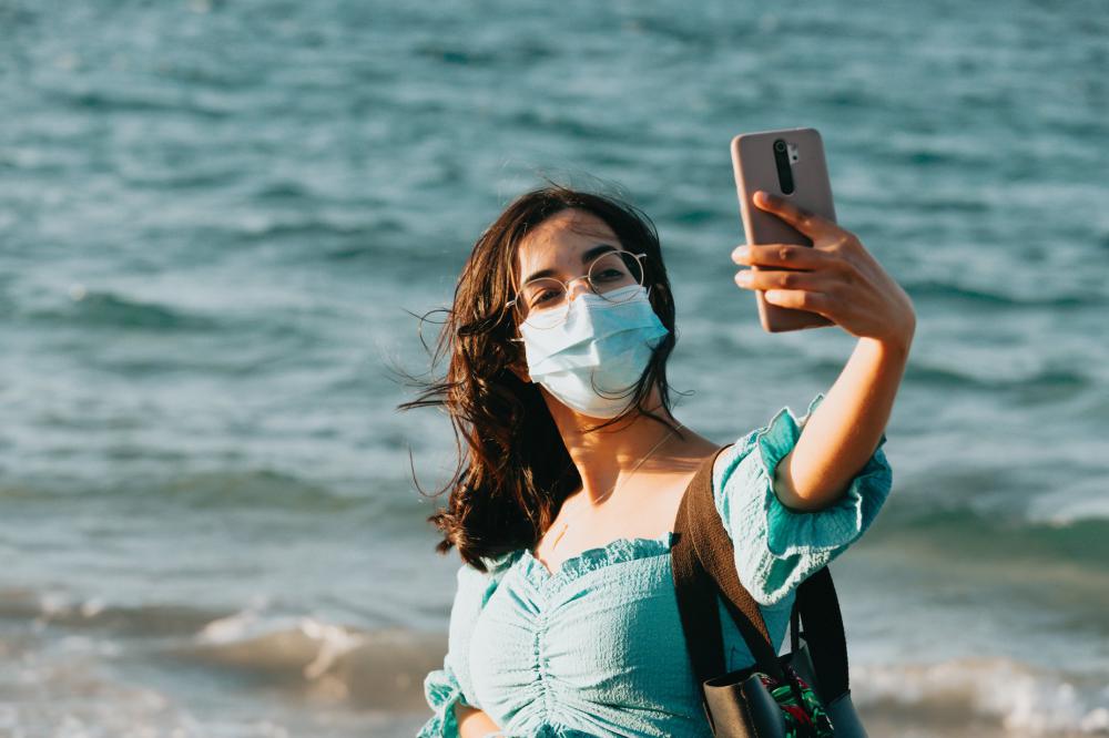 Woman In A Facemask Takes A Selfie With Her Phone Photo Woman In A Facemask Takes A Selfie With Her Phone Photo