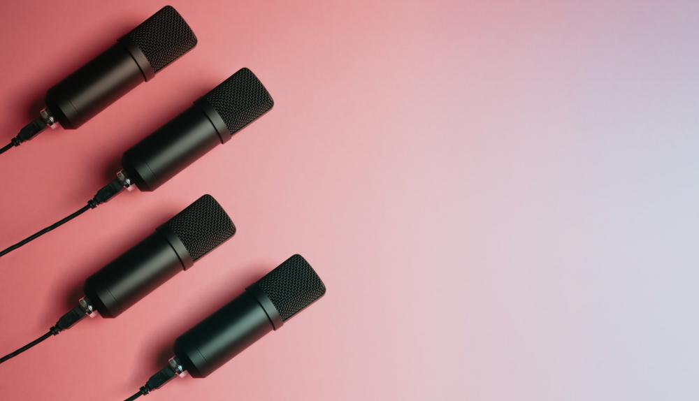 Four Black Microphones Lay On A Pink Background Photo Four Black Microphones Lay On A Pink Background Photo