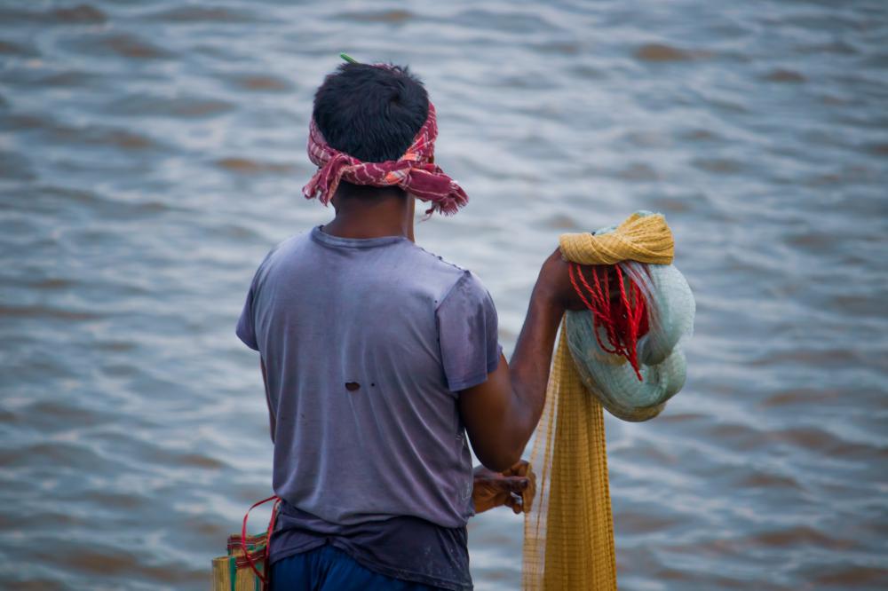 Person Holding A Fishing Net Faces Blue Water Photo Person Holding A Fishing Net Faces Blue Water Photo