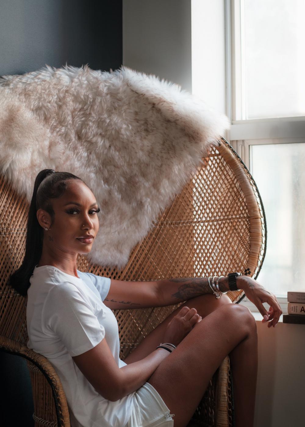 Woman Dressed In White T Shirt In A Wicker Peacock Chair Photo Woman Dressed In White T Shirt In A Wicker Peacock Chair Photo