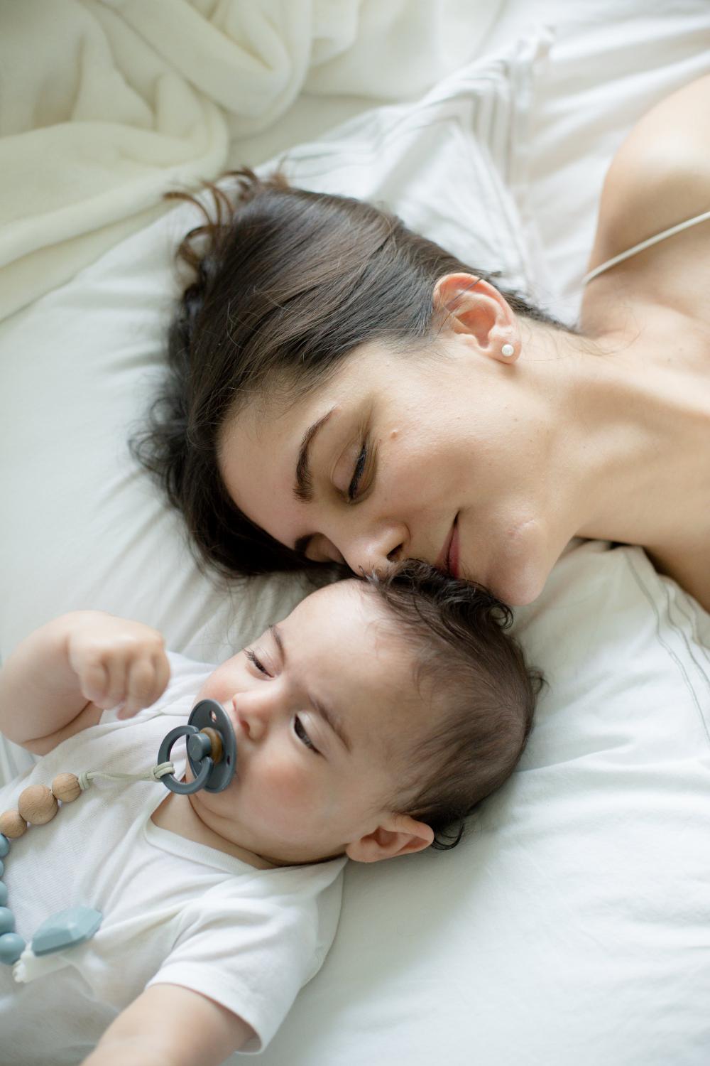 Parent And Child Lay On A White Bed Together Photo Parent And Child Lay On A White Bed Together Photo