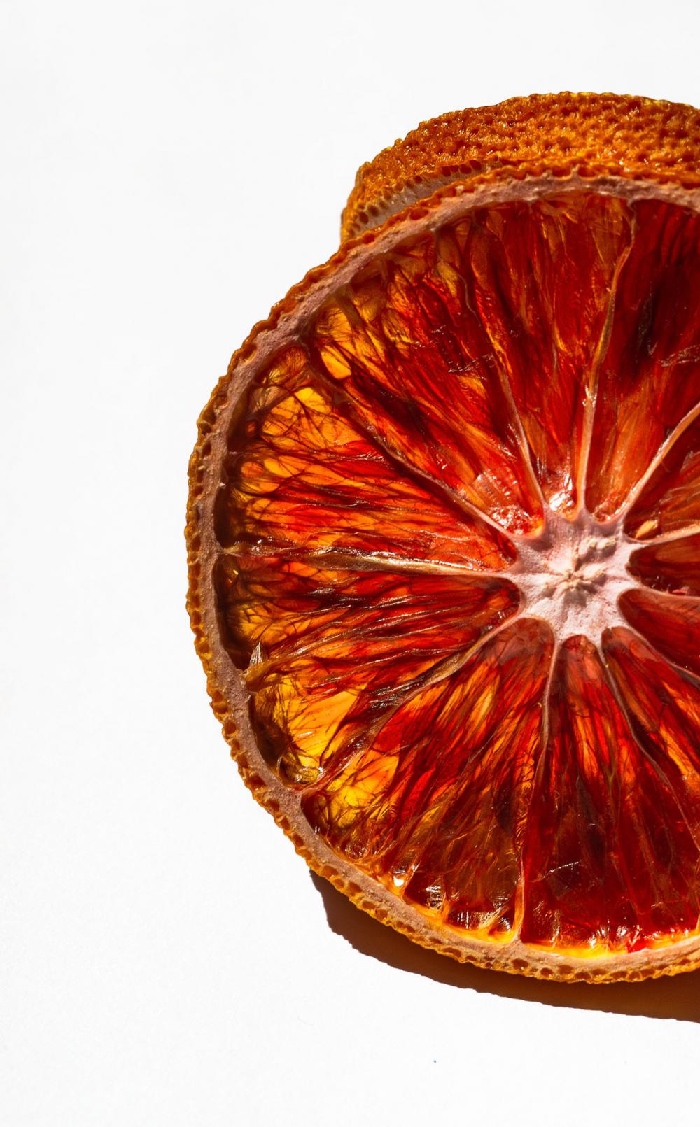 Close Up Of A Slice Of Orange Against White Photo Close Up Of A Slice Of Orange Against White Photo