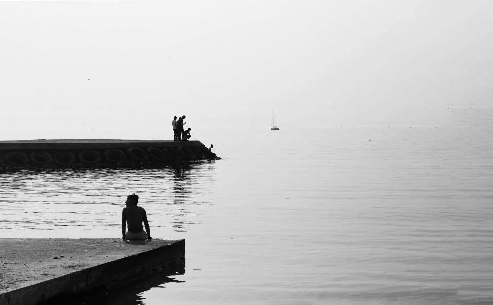 Black And White Photo Of People On A Cement Shore By Still Water Photo Black And White Photo Of People On A Cement Shore By Still Water Photo