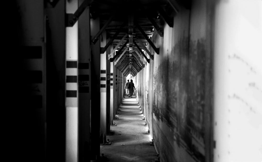 Two People Walk Down A Long Hallway Photo Two People Walk Down A Long Hallway Photo