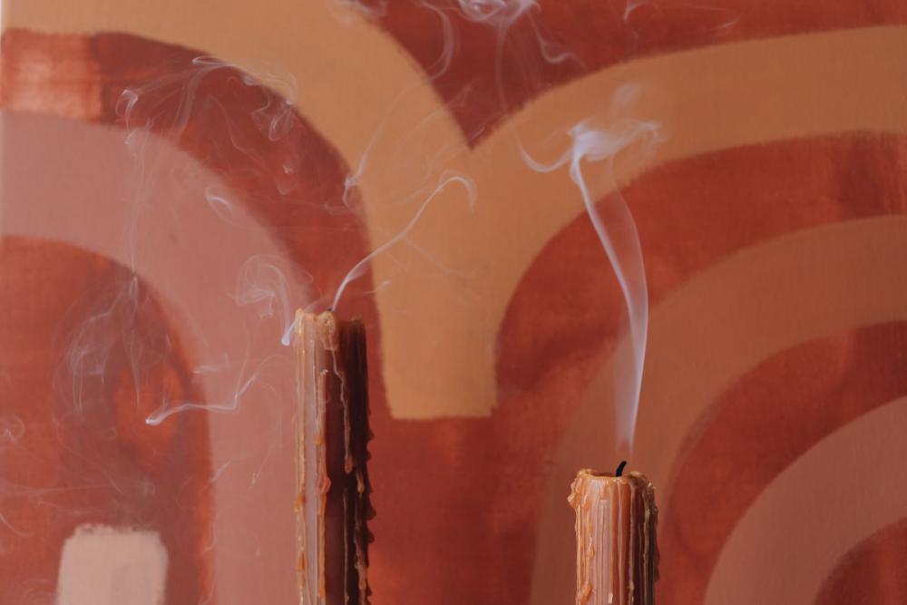 Orange-colored candles on the background of the painting Orange-colored candles on the background of the painting