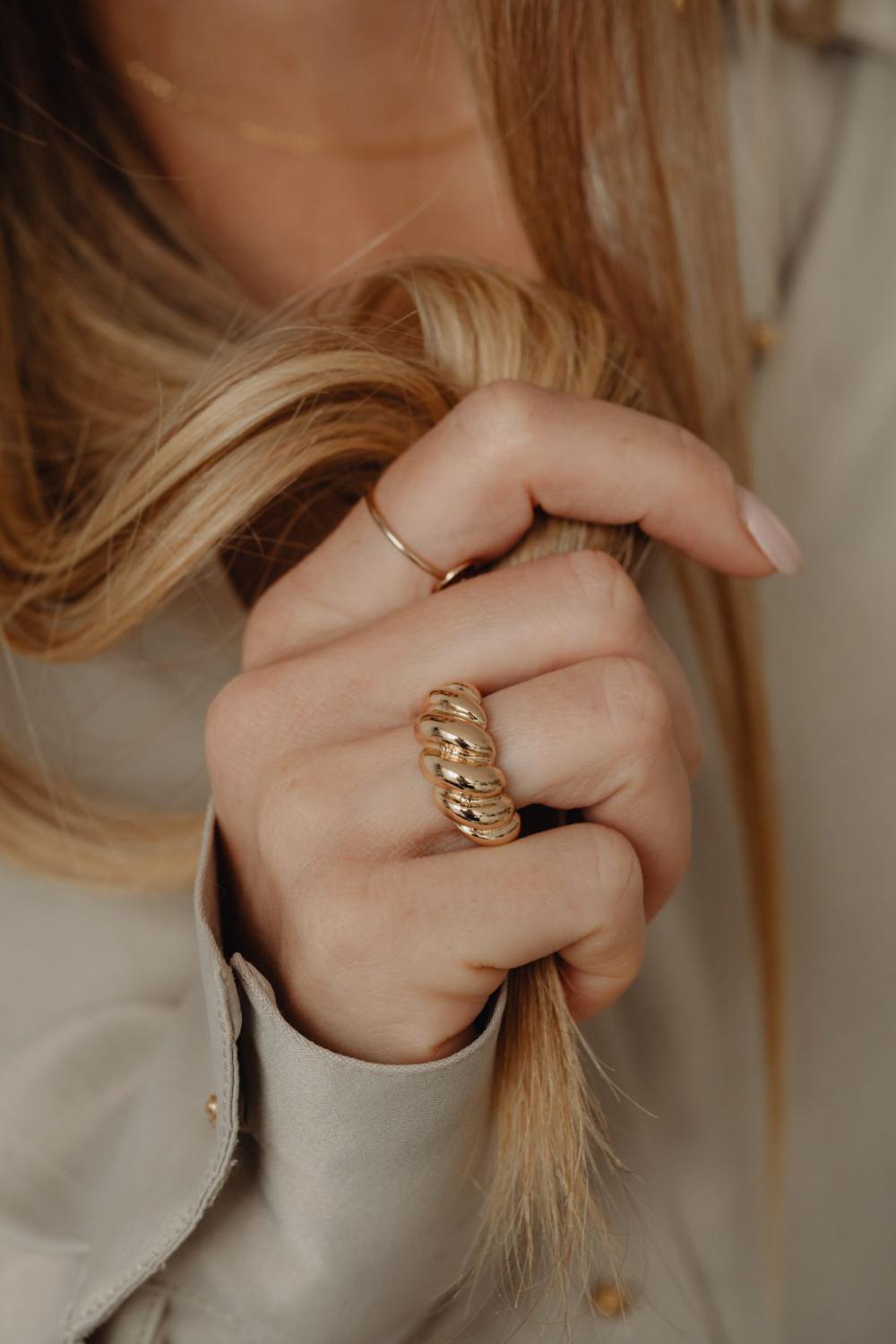 Details of gold jewelry - beautiful woman wearing a tan silk shirt Details of gold jewelry - beautiful woman wearing a tan silk shirt