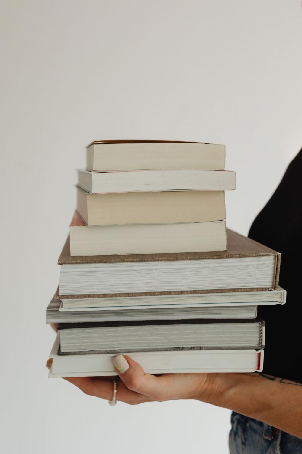 Woman in light-colored jeans with books Woman in light-colored jeans with books
