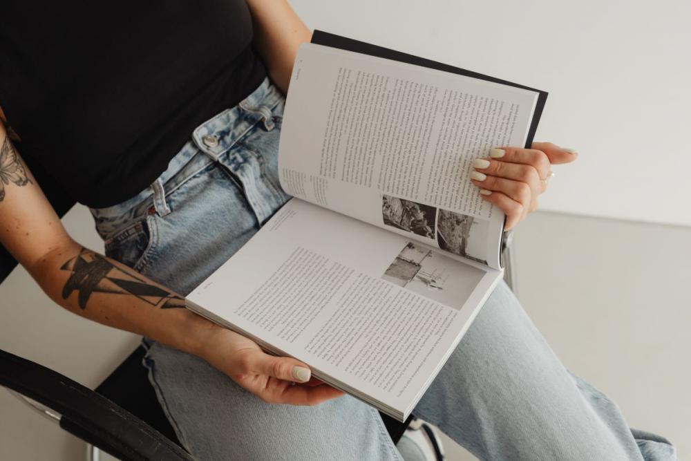 Woman in light-colored jeans with books Woman in light-colored jeans with books