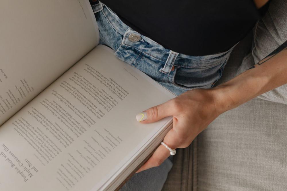 Woman in light-colored jeans with books Woman in light-colored jeans with books