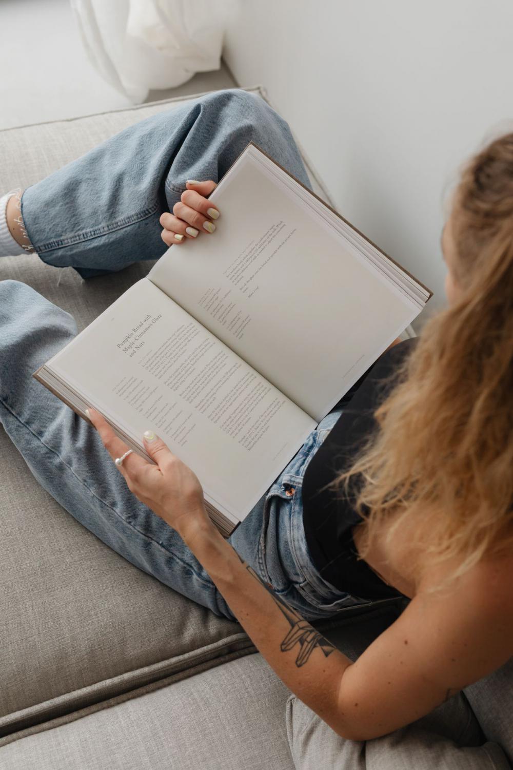 Woman in light-colored jeans with books Woman in light-colored jeans with books