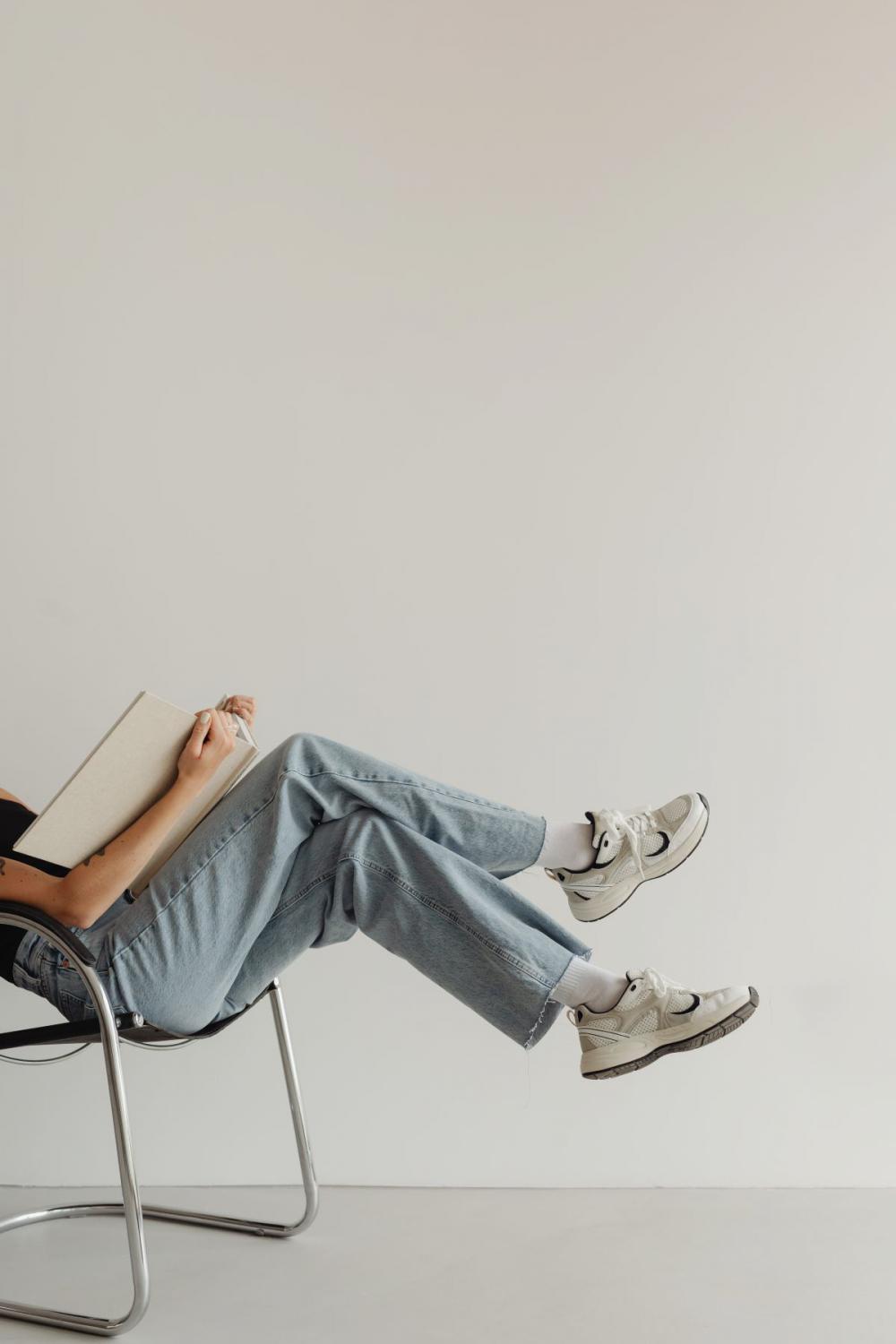 Woman in light-colored jeans with books Woman in light-colored jeans with books