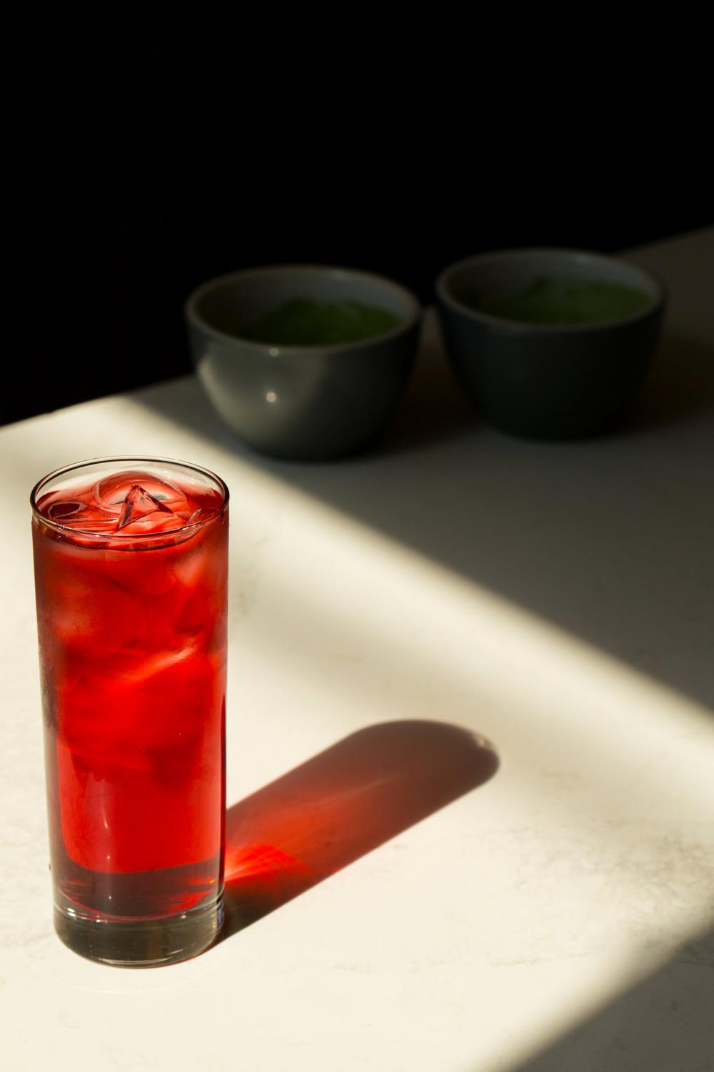Glass With Iced Red Beverage Reflects On A White Table Photo Glass With Iced Red Beverage Reflects On A White Table Photo