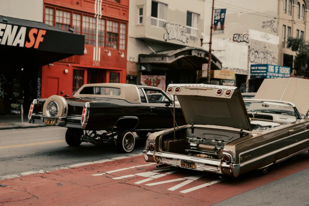 Two Customized Cars Rolling Through A City Street Photo Two Customized Cars Rolling Through A City Street Photo