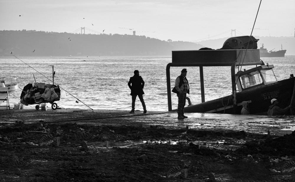 Two People Stands On The Shore Next To A Boat Photo Two People Stands On The Shore Next To A Boat Photo