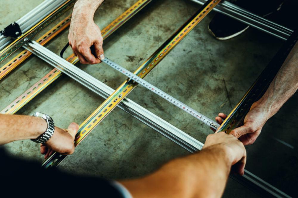 Teamwork in Construction – Measuring Metal Frame with Precision Teamwork in Construction – Measuring Metal Frame with Precision