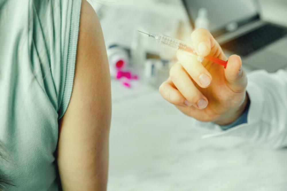 Doctor giving injection vaccine to patient arm Doctor giving injection vaccine to patient arm