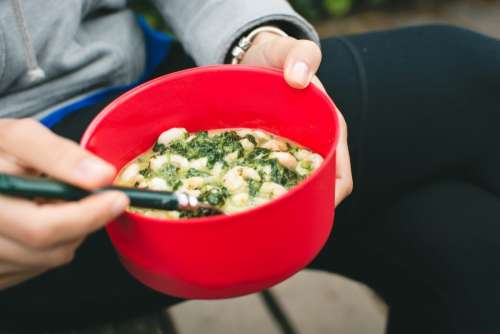 Cooking shrimps with spinach outside camping