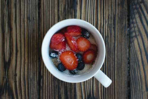 Cup of oatmeal with berries and coconut